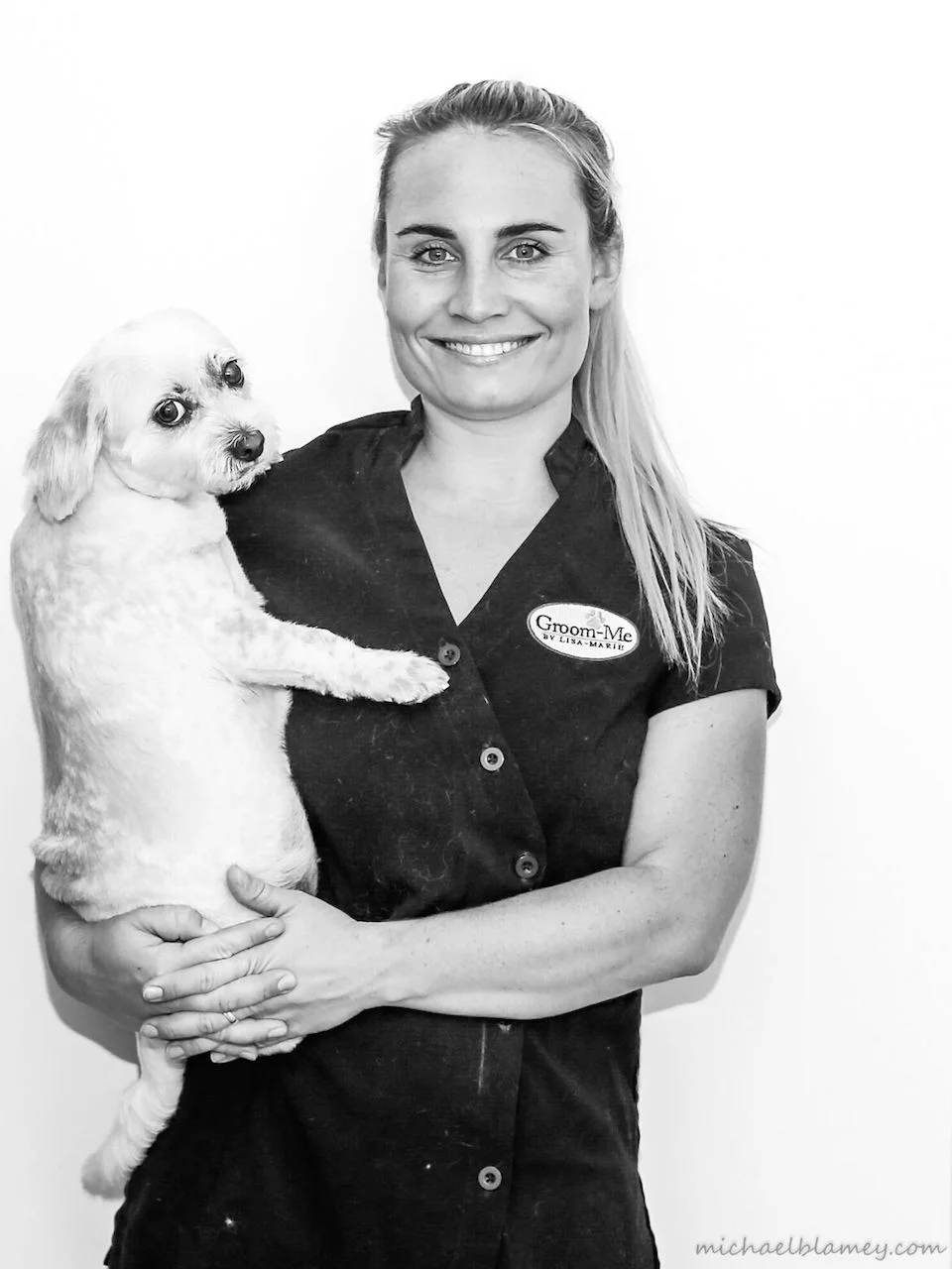 Lisa-Marie Hinton holding a freshly-groomed white dog